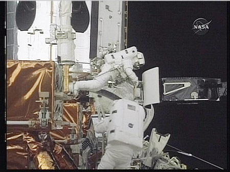 In this May 14, 2009 image taken from NASA video, astronaut John Grunsfeld (top) makes a repair with colleague Drew Feustel during the first space walk to repair the Hubble space telescope. 